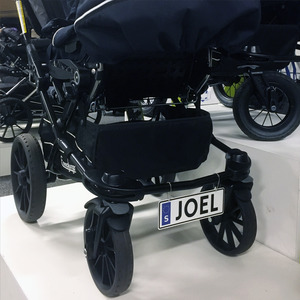 Detaljbild på barnvagnsskylt med egen text och reflex